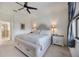 Bright main bedroom featuring a ceiling fan, a king bed, and two nightstands with lamps at 13422 Saw Palm Creek Trl, Lakewood Ranch, FL 34211
