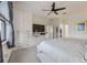 Bright main bedroom featuring built in closet, flat screen TV, ceiling fan and plush carpet at 13422 Saw Palm Creek Trl, Lakewood Ranch, FL 34211