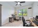 Well-lit office space with a ceiling fan, two desks, a rolling office chair and large windows at 13422 Saw Palm Creek Trl, Lakewood Ranch, FL 34211