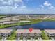 Drone shot of a residential neighborhood beside a pond with lush green surroundings at 15131 Sunny Day Dr, Bradenton, FL 34211