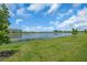 Expansive green backyard with a picturesque lake view, perfect for relaxation and outdoor activities at 15131 Sunny Day Dr, Bradenton, FL 34211