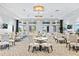 A bright dining area is furnished with multiple tables and chairs near doors leading to an outdoor space at 15131 Sunny Day Dr, Bradenton, FL 34211