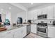 Stylish kitchen featuring stainless steel appliances, white cabinetry, and elegant granite countertops at 15131 Sunny Day Dr, Bradenton, FL 34211