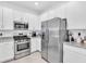 Well-equipped kitchen boasting stainless steel appliances, white cabinets, and beautiful countertops at 15131 Sunny Day Dr, Bradenton, FL 34211