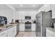 Modern kitchen with stainless steel appliances, white cabinets, and granite countertops at 15131 Sunny Day Dr, Bradenton, FL 34211