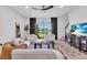 Bright living room featuring modern furnishings, dark curtains, and large windows overlooking the backyard at 15131 Sunny Day Dr, Bradenton, FL 34211