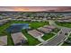 Stunning aerial view of a Primary-planned community with serene ponds and luxurious homes during a picturesque sunset at 15716 Barefoot Beach Dr, Bradenton, FL 34211
