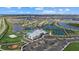 Aerial view features community clubhouse, tennis courts, pool, playground, and parking, nestled in a scenic residential area at 15716 Barefoot Beach Dr, Bradenton, FL 34211