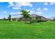 Large, well-maintained backyard with lush green grass, screened lanai and carefully designed landscaping for outdoor enjoyment at 15716 Barefoot Beach Dr, Bradenton, FL 34211