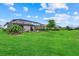 Expansive backyard featuring lush green grass, a screened-in lanai and privacy landscaping, perfect for relaxing and entertaining at 15716 Barefoot Beach Dr, Bradenton, FL 34211