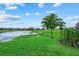 Lush backyard view, featuring a pond, mature trees, and manicured lawn at 15716 Barefoot Beach Dr, Bradenton, FL 34211