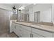 Bathroom featuring double sinks, granite countertops, stylish fixtures, and a glass-enclosed shower at 15716 Barefoot Beach Dr, Bradenton, FL 34211