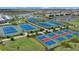The property's aerial view highlights tennis and basketball courts along with aquatic facilities and green spaces at 15716 Barefoot Beach Dr, Bradenton, FL 34211