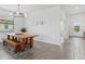 Bright dining area with modern light fixture, wood table, and view of the entry at 15716 Barefoot Beach Dr, Bradenton, FL 34211