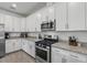 Well-lit white kitchen featuring stainless steel appliances and granite countertops at 15716 Barefoot Beach Dr, Bradenton, FL 34211
