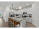 White kitchen with stainless steel appliances, granite countertops and island with seating at 15716 Barefoot Beach Dr, Bradenton, FL 34211