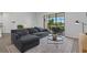 Comfortable living room featuring a gray sectional sofa and a view of the screened outdoor living space at 15716 Barefoot Beach Dr, Bradenton, FL 34211