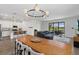 Bright open-concept living room with modern lighting, gray sofa, and expansive sliding glass doors to screened porch at 15716 Barefoot Beach Dr, Bradenton, FL 34211
