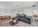 Open living space with modern lighting, comfortable gray sectional sofa, and view to kitchen and bedroom at 15716 Barefoot Beach Dr, Bradenton, FL 34211