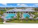 Aerial view highlighting community pools, sun loungers, and a clubhouse, creating a luxurious and relaxing atmosphere at 15716 Barefoot Beach Dr, Bradenton, FL 34211