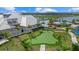 A community putting green area surrounded by palm trees and adjacent to a pool and clubhouse at 15716 Barefoot Beach Dr, Bradenton, FL 34211