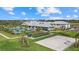 Scenic aerial view of the community's recreational area featuring a bocce ball court, volleyball court, pool, and clubhouse at 15716 Barefoot Beach Dr, Bradenton, FL 34211