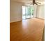 Spacious living room with laminate flooring, ceiling fan, and sliding glass doors at 1604 Chevy Chase Dr, Sun City Center, FL 33573