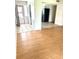 Spacious living room with hardwood floors leading into the kitchen with stainless steel refrigerator and tile flooring at 1604 Chevy Chase Dr, Sun City Center, FL 33573