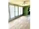 Sunroom with tile flooring, bright green accent wall, and multiple windows at 1604 Chevy Chase Dr, Sun City Center, FL 33573