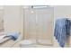 Bathroom featuring a glass-door shower with beige tile surround and chrome hardware at 17612 Northwood St, Lakewood Ranch, FL 34202