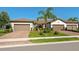 Attractive home with two-car garage, brick driveway, and lush landscaping enhancing curb appeal at 17612 Northwood St, Lakewood Ranch, FL 34202