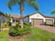 Beautiful home featuring a two-car garage, brick driveway, and well-manicured landscaping at 17612 Northwood St, Lakewood Ranch, FL 34202