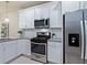 Modern kitchen with stainless steel appliances, granite countertops, and white cabinets at 17612 Northwood St, Lakewood Ranch, FL 34202