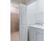 Functional laundry area with washer, dryer, shelving, and a view to the tiled shower at 17612 Northwood St, Lakewood Ranch, FL 34202