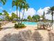Beautiful community pool area with lush landscaping, tables, chairs, and umbrellas for relaxing poolside at 17612 Northwood St, Lakewood Ranch, FL 34202