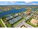 An aerial view shows community amenities with tennis courts, a swimming pool, and a lakefront setting at 19023 Mangieri St, Venice, FL 34293