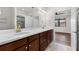 Bathroom with double sinks, wood cabinets, and a shower with custom tile at 19023 Mangieri St, Venice, FL 34293