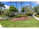 The Island Walk community entrance with colorful flowerbeds and lush landscaping creates a welcoming and impressive arrival at 19023 Mangieri St, Venice, FL 34293