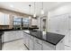 Bright kitchen featuring granite countertops, white cabinets, stainless steel appliances, pendant lighting and brick accents at 19023 Mangieri St, Venice, FL 34293