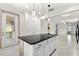 Kitchen featuring a granite island, white cabinets, tile floors, and pendant lighting with outdoor access to patio at 19023 Mangieri St, Venice, FL 34293