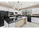 Bright kitchen featuring granite countertops, white cabinets, stainless steel appliances, pendant lighting and brick accents at 19023 Mangieri St, Venice, FL 34293