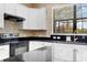 Modern kitchen featuring white cabinets, granite countertops, stainless steel appliances, and a stylish backsplash at 19023 Mangieri St, Venice, FL 34293