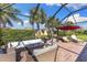 Covered brick patio featuring lounge furniture and views of the landscaped backyard at 19023 Mangieri St, Venice, FL 34293