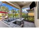 Screened-in patio with lounge furniture, outdoor TV, and views of the backyard and landscaping at 19023 Mangieri St, Venice, FL 34293