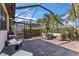 Enjoy outdoor living on the screened patio with comfortable seating and a view of the surrounding greenery at 19023 Mangieri St, Venice, FL 34293