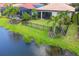 The back of the house features a green lawn, black metal fencing, and a scenic lake view at 201 Vinadio Blvd, Nokomis, FL 34275