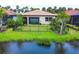 The back of the house features a green lawn, black metal fencing, and a scenic lake view at 201 Vinadio Blvd, Nokomis, FL 34275