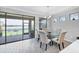 Bright dining area with lake view, glass table, and stylish chairs at 201 Vinadio Blvd, Nokomis, FL 34275