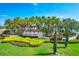 Community entrance sign for Toscana Isles, featuring lush landscaping and palm trees against a bright blue sky at 201 Vinadio Blvd, Nokomis, FL 34275