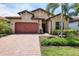 Charming single-Gathering home featuring a red brick driveway, two-car garage, and lush tropical landscaping at 201 Vinadio Blvd, Nokomis, FL 34275